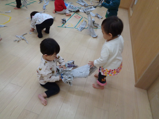 新聞紙を丸めたりして遊ぶ園児たち