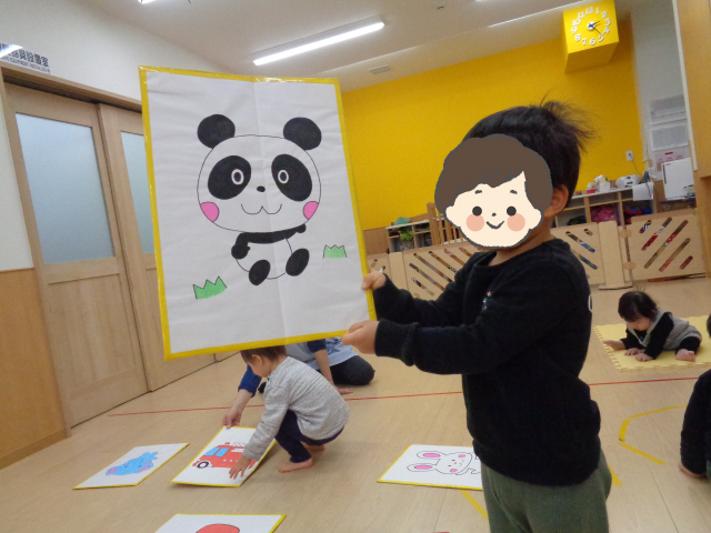 パンダが描かれた大きなかるたを持つ子ども